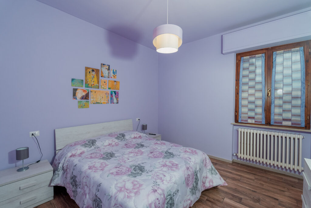 Camera con letto matrimoniale e vista sulla cupola della Basilica
